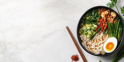 Soup with noodles served on marble table, chopsticks and herbs in the back photo