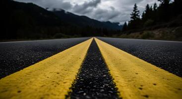 Mountain Road with Yellow Center Lines under Cloudy Sky photo