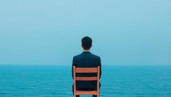 Lonely adult man sitting alone by the sea photo