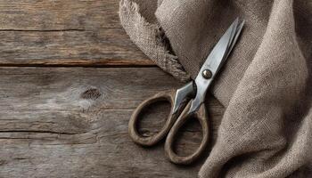 Rustic crafting scene with old metal scissors and linen fabric on wooden board photo