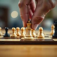 A person is placing a piece of chess on a board photo