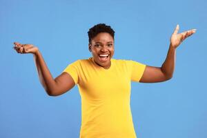 Come On. Joyful African American Plus-Size Woman Gesturing With Raised Hands Urging To Stand Up Standing Posing Over Blue Studio Background, Smiling To Camera. photo