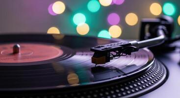 A close up view of a vinyl record playing on a turntable with colorful bokeh lights. photo