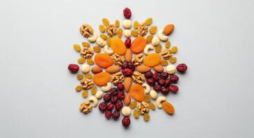 Top view of a decorative arrangement of assorted dried fruits and nuts forming a unique pattern. photo