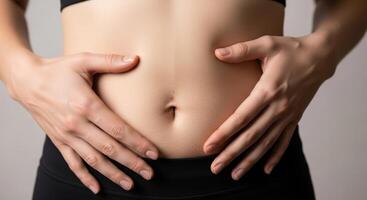 Close up of a woman hands on her stomach, representing health, digestion, and body care. photo