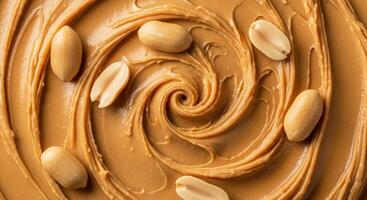 Close up top view of creamy peanut butter with a swirled texture and whole peanuts. photo