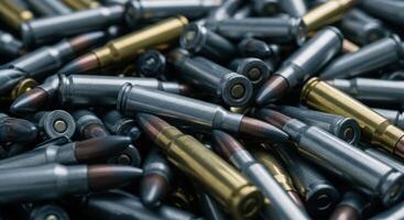 Close up view of a large pile of silver and brass rifle ammunition cartridges photo