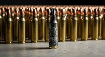 Unique black textured rifle cartridge standing out among many golden ammunition rounds. photo