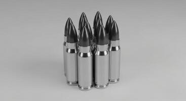 Shiny rifle bullets with silver casings and black tips neatly arranged on a grey surface. photo