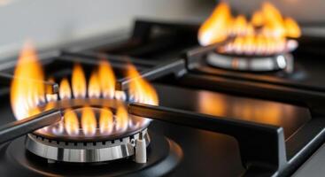 Close up of bright orange and blue flames burning on a gas stove burner photo