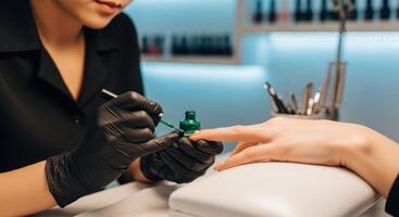 Manicurist applies green nail polish to a client hand in a professional beauty salon. photo