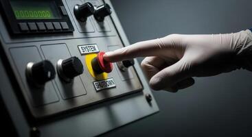 Gloved hand pressing red emergency shutdown button on an industrial control panel photo