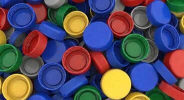 Vibrant close up of a large pile of colorful plastic bottle caps for recycling concept photo