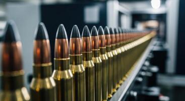 Close up of rifle bullets on an assembly line in a modern ammunition factory photo