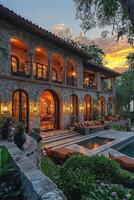 A luxurious stone house with a pool at sunset photo