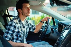 Man looking at rear view mirror while driving modern car photo