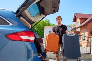 Man with suitcases near car, preparing for moving photo