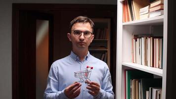 A man holding a shopping cart in front of a book shelf video