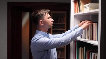 A man is looking at books on shelf video