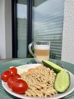 A hearty lunch of pasta, vegetables and scrambled eggs, a glass of coffee, cappuccino in the fresh air on the terrace photo
