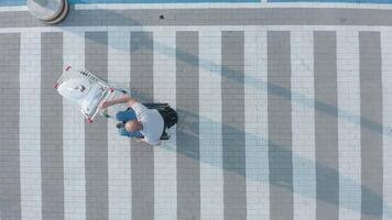 Aerial view of man pushing cart on crosswalk video