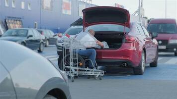 Man organizing bags at trunk in parking area video