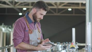 Man inputting brewing data on a digital tablet video