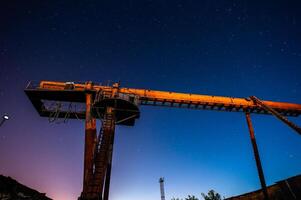 Gantry Crane at Scrap Yard Under Starry Night Sky photo