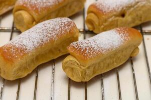 Golden homemade Parker House rolls resting on a wire rack after baking, fresh from the oven and ready to serve. photo