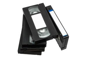 Stack of vintage VHS cassettes with blank white labels, arranged on white background photo