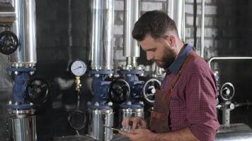 Worker reading data on a digital controller in a fermentation room video