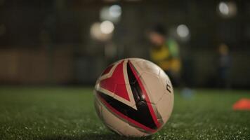 A children's football team trains at the stadium under the guidance of a coach. Kids in sports uniforms practice ball exercises, improve technique, and develop teamwork on the green field 40 video