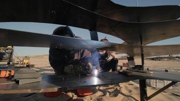 Close-up of UAV rotor system with reflected sunlight in sandy testing area. video