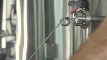 Macro view of beer pouring from metal valve into sample glass video