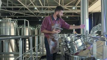 Brewer checking notes and observing the brewing process video