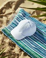 Relaxing Moment at the Beach With a Towel and a White Cap on Sandy Shore. photo
