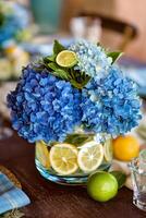 Bright Blue Hydrangeas and Citrus Accents Adorn Elegant Table Setting for Summer Gathering. photo