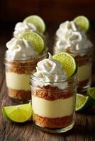 Delicious Key Lime Pie Desserts in Mason Jars With Whipped Cream and Lime Slices. photo