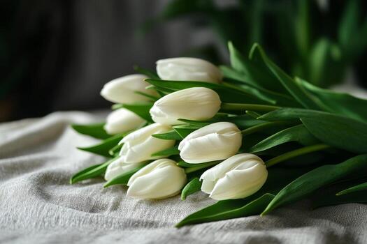 Fresco blanco tulipanes arreglado esmeradamente en un texturizado superficie en natural ligero foto