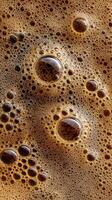 Close up of Frothy Coffee in a Glass Cup on a Wooden Table. photo