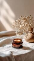 Amber Jar Stands out on Neutral Surface With Shadows and Dried Flowers in a Cozy Setting. photo