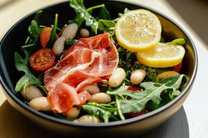 Fresh Salad With Arugula, Tomatoes, Prosciutto, and Lemon Slices on a Wooden Table photo