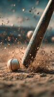 Baseball Bat Strikes Ball in Action on a Dusty Field During Sunset photo
