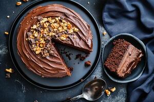Chocolate Cake With Nuts Sliced on a Black Plate Accompanied by a Small Serving photo