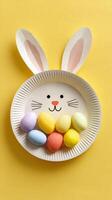 Creative Easter Bunny Plate With Colorful Eggs on Bright Yellow Background photo