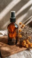 Brown Glass Spray Bottle With Dried Flowers on Wooden Surface in Soft Natural Light. photo