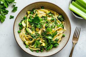 Fresh Green Pasta With Peas and Herbs Served in a Bowl on a Light Surface. photo