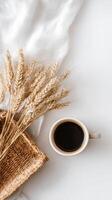 Warm Coffee Cup Next to Dried Wheat on a White Surface in a Cozy Setting photo