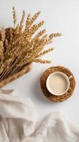 Warm Coffee Cup Next to Dried Wheat on a White Surface in a Cozy Setting. photo