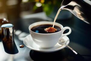 Coffee Being Poured Into a Cup on a Marble Table With Sunlight Streaming in From the Side. photo